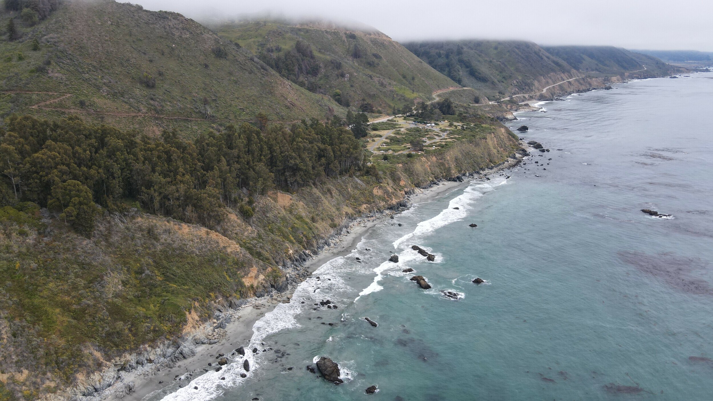 Aerial view of Limekiln State Park in California, showcasing the rugged coastline, dense redwood forests.