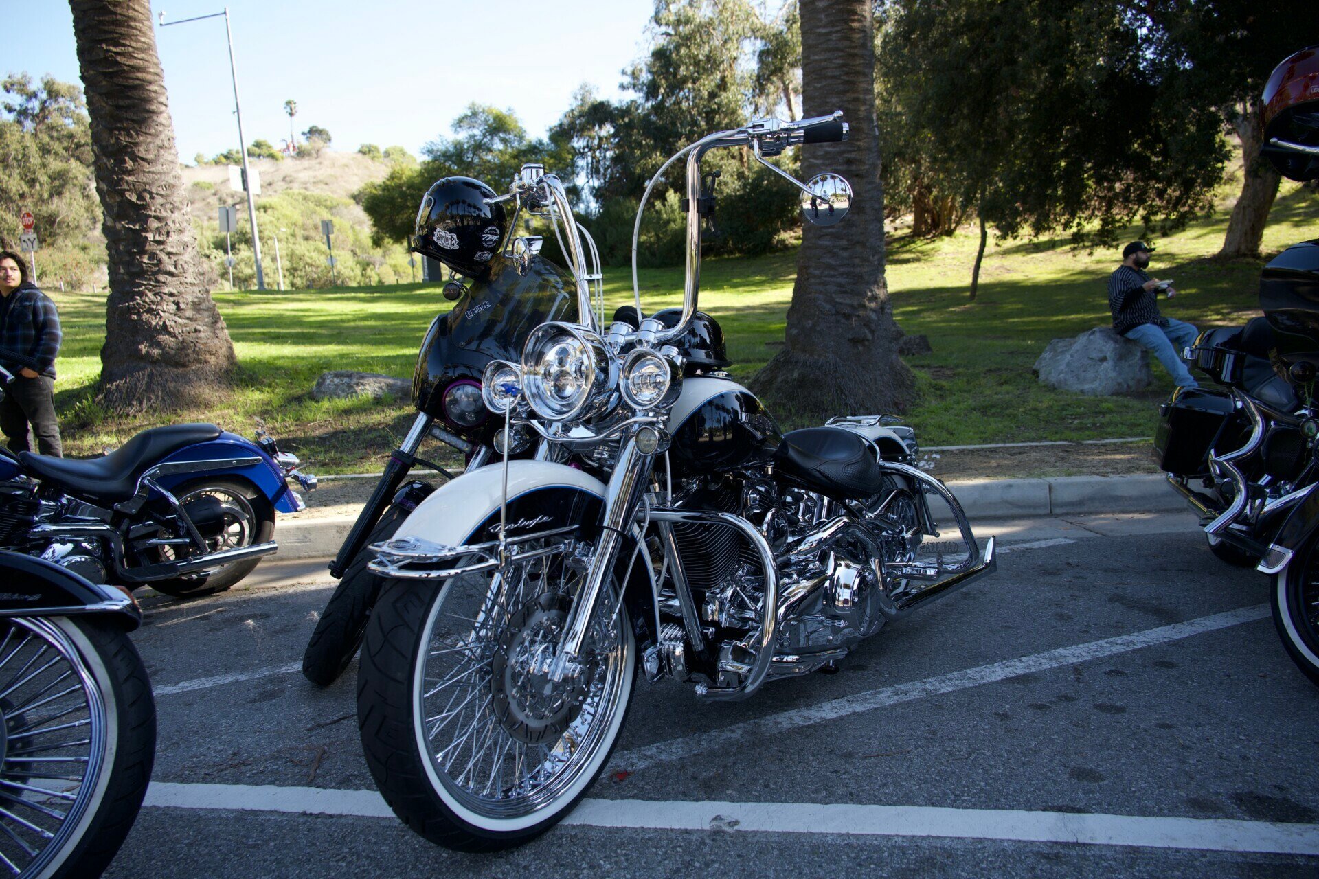 Classic black and white motorcycle with high handlebars at an outdoor event in Elysian Park, Los Angeles