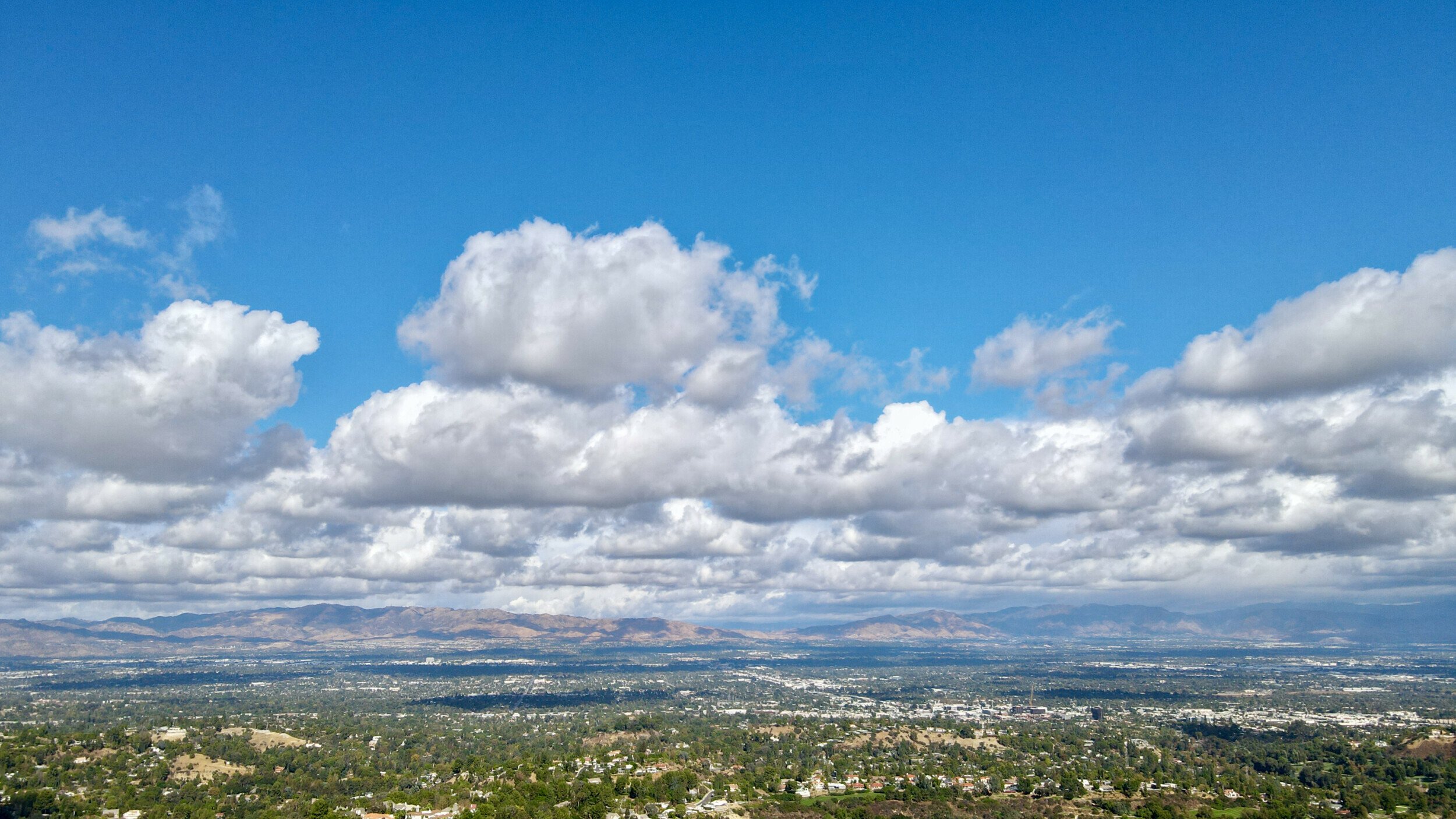 Aerial view of Marvin Braude Mulholland Park with cumulus clouds shadowing over the landscape, captured by DJI Mavic Air 2