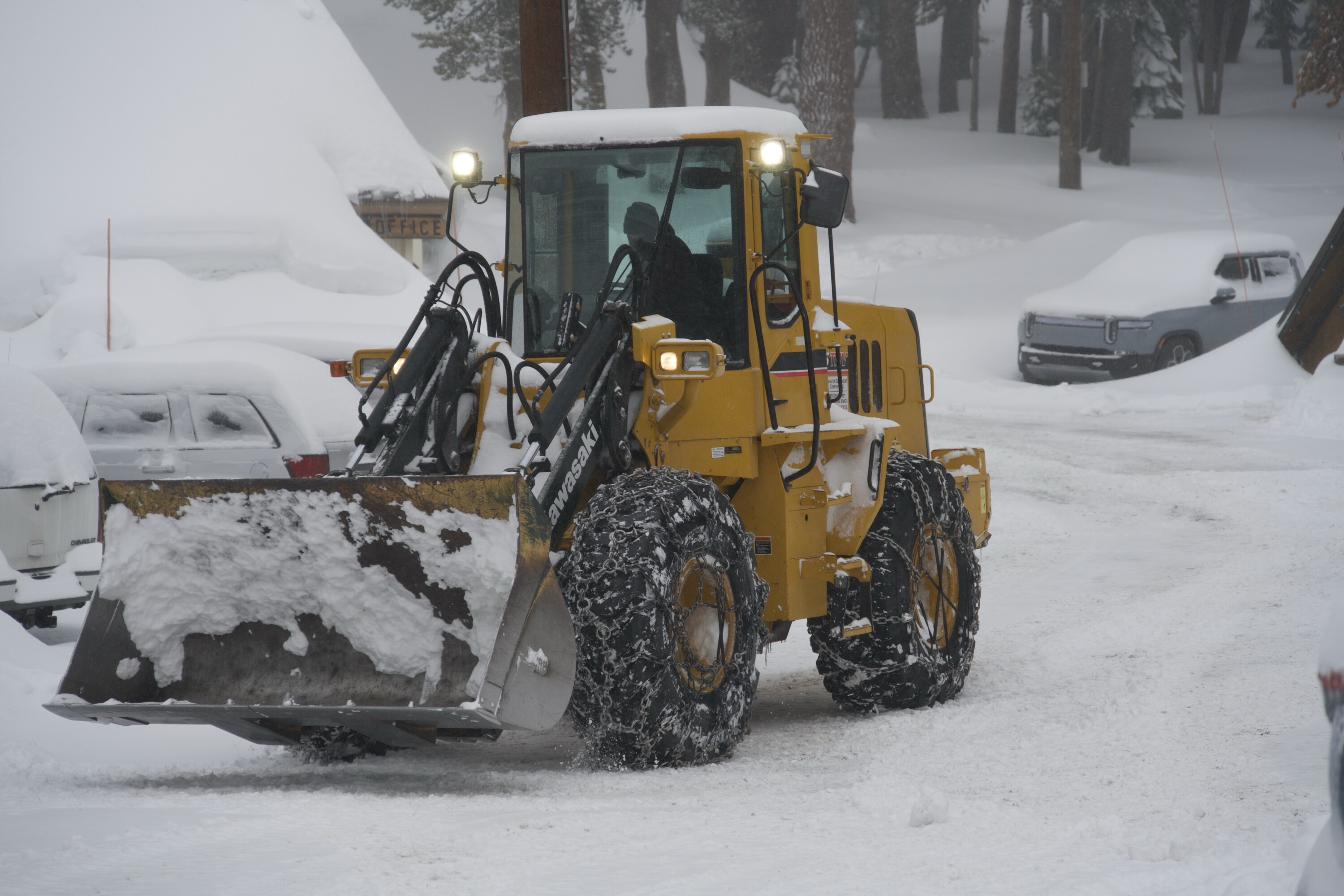 A bulldozer clearing snow from a parking lot at Mammoth Lakes.