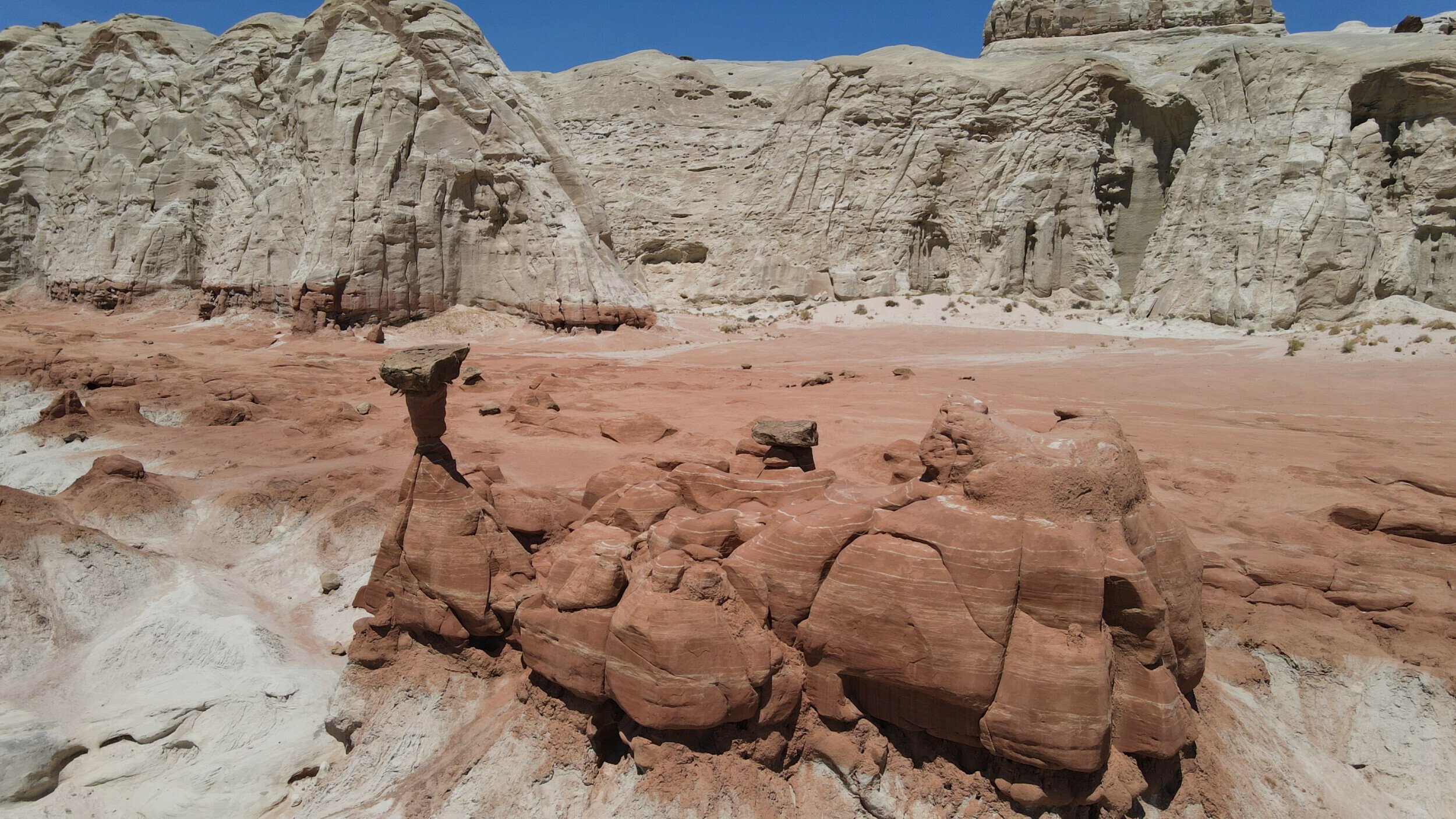 Sun-drenched Toadstool Hoodoos at Kanab, Utah, has unique rock formations and contrasting white and red sandstone layers.
